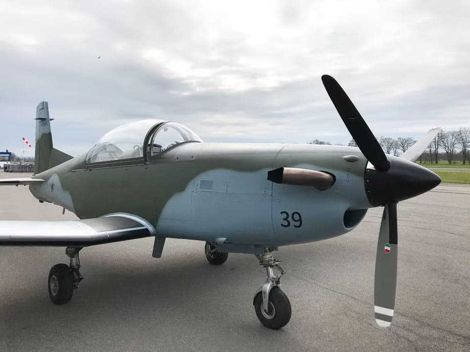 Close up of a Tucano aircraft with a camouflage paint scheme.