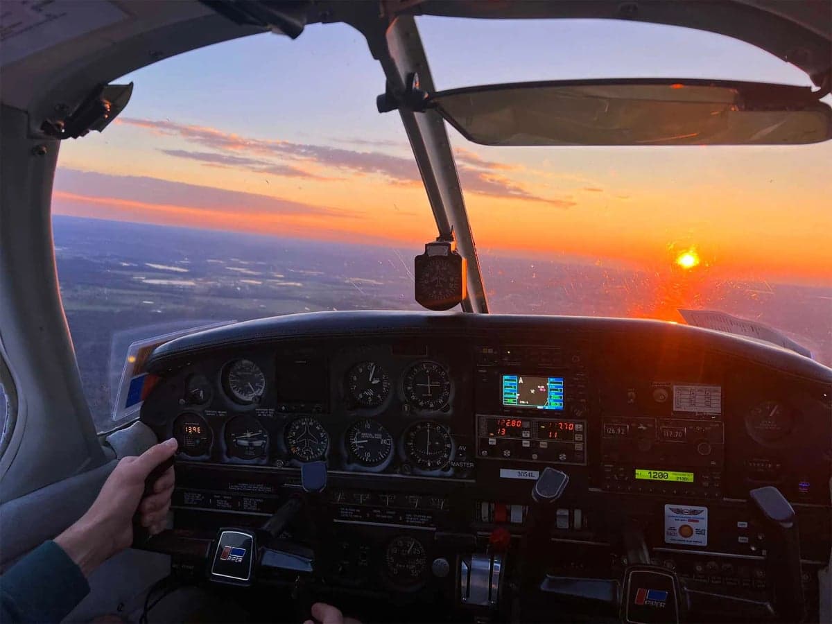View of the cockpit instrument panel during a sunset flight.
