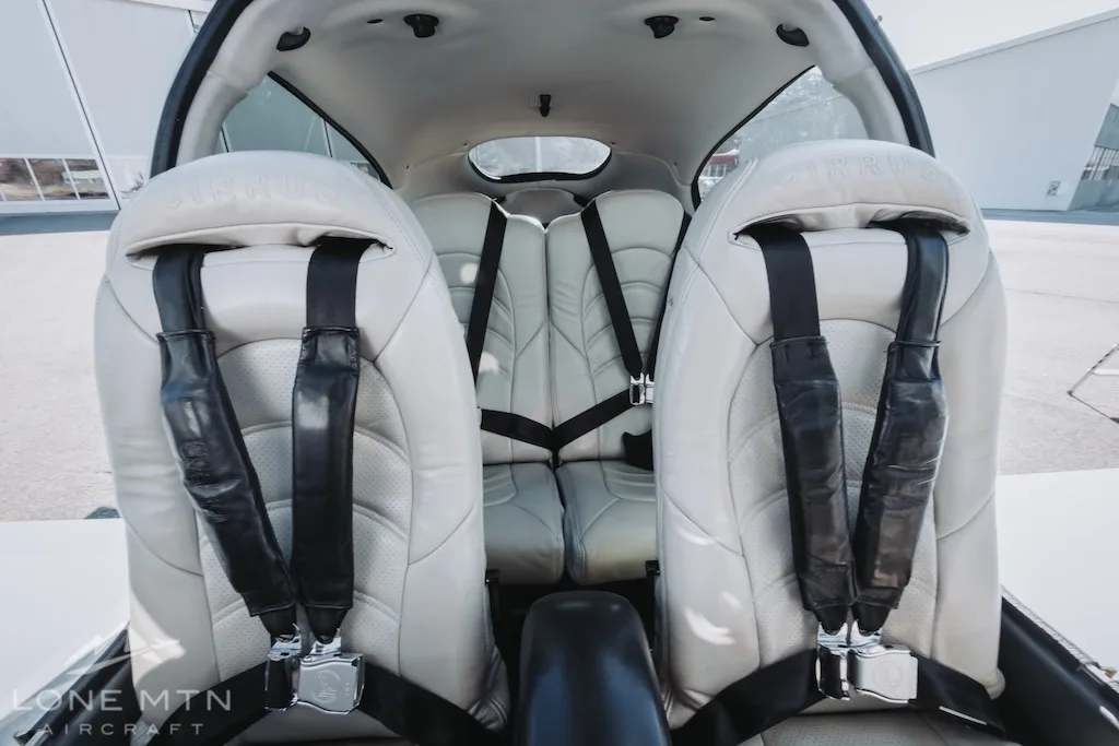A view of the light-colored leather front and rear seats in the cabin of the Cirrus SR22 aircraft.