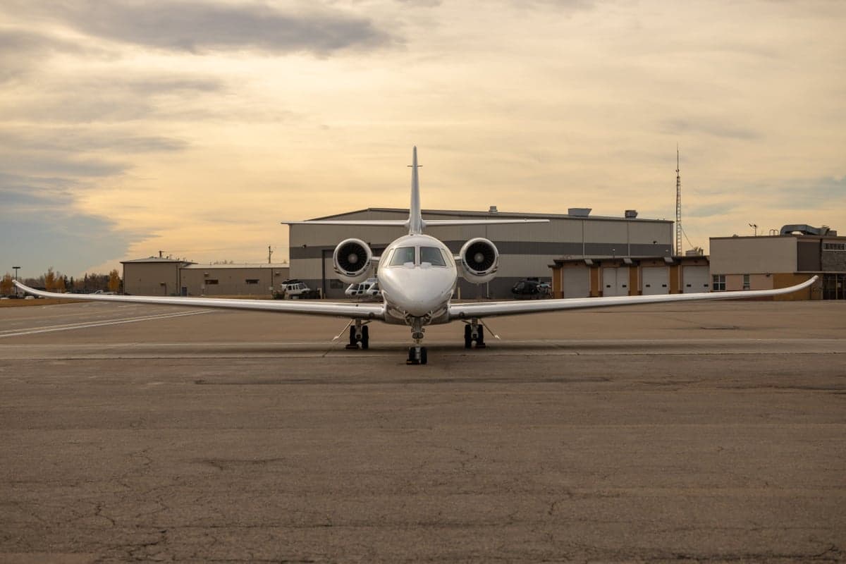 Jet aircraft parked on the tarmac in front of a building.