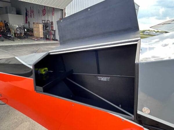 Close-up of the aircraft's open baggage compartment with a green tool inside.