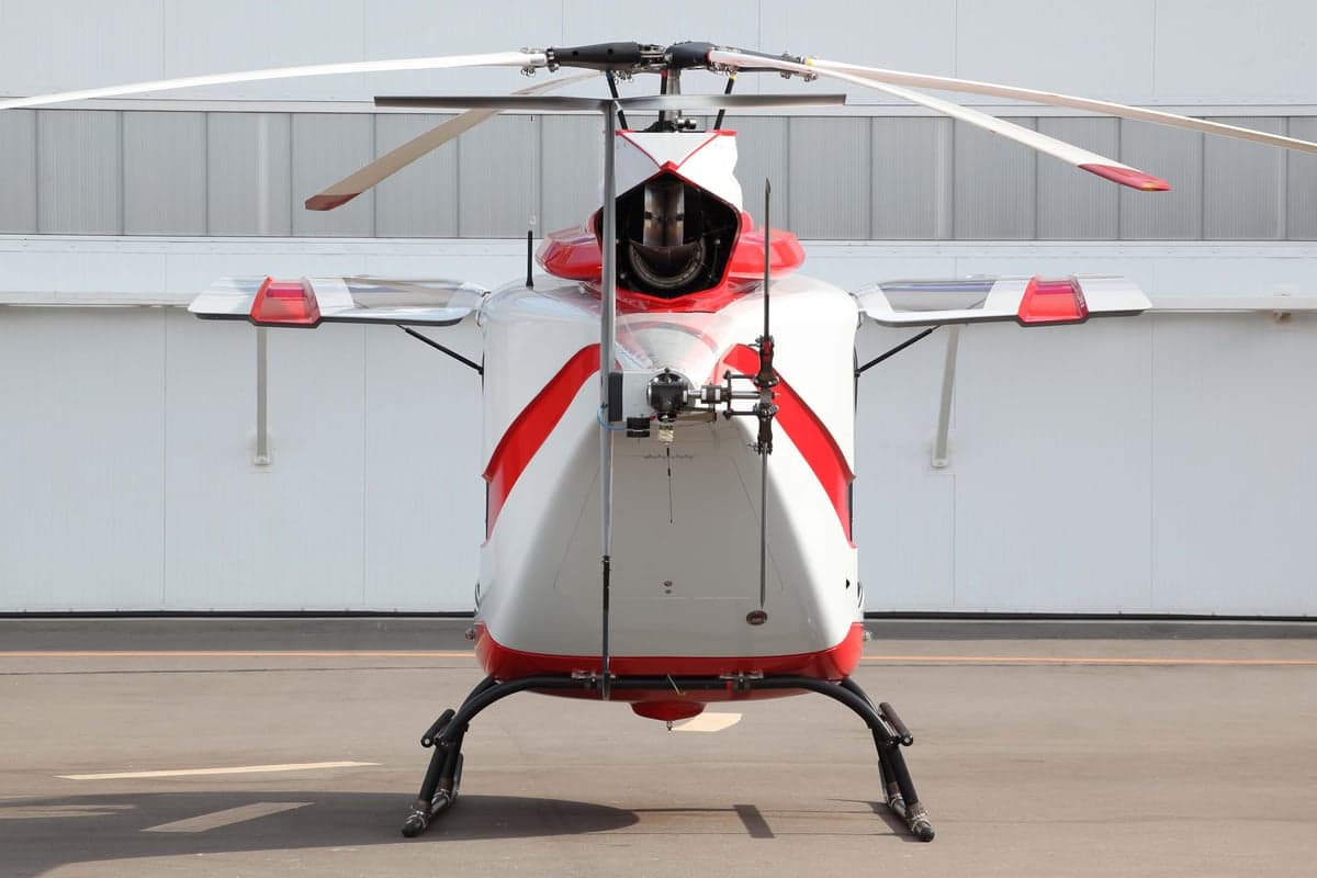 A rear view of the white and red helicopter on the tarmac.