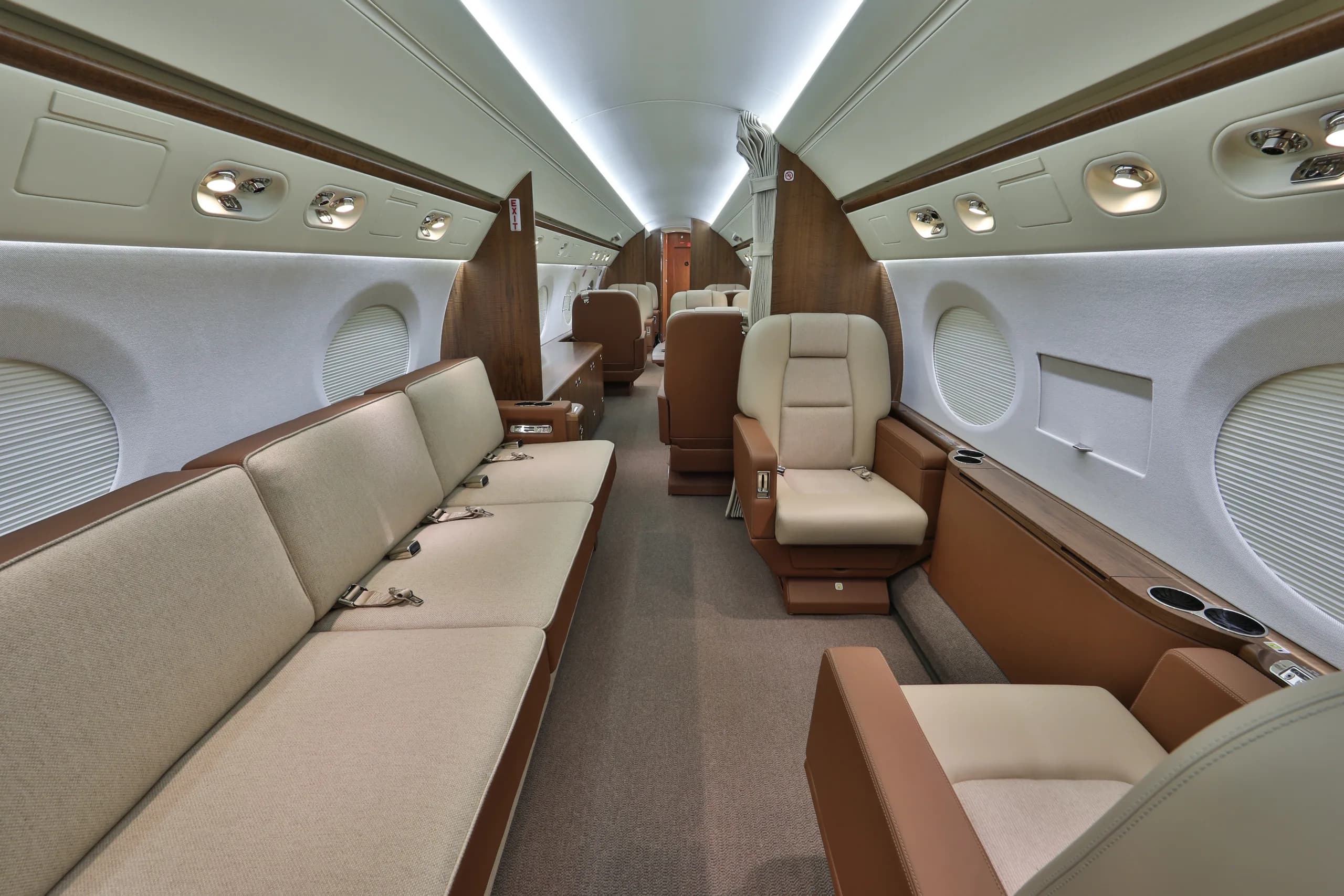 View of the aircraft's interior with a couch and tan leather seats.