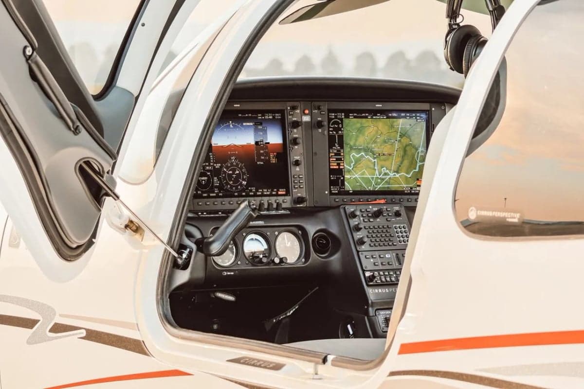 Cockpit view of the Cirrus aircraft instrument panel through the open door.