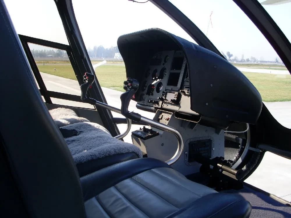 View of the helicopter cockpit with instrument panel and seats.
