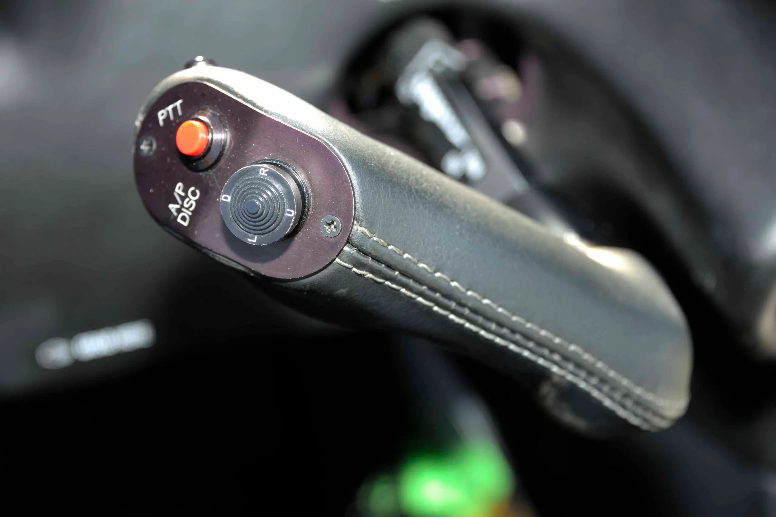 A close-up of the pilot's control yoke handle with push-to-talk and autopilot disconnect buttons.