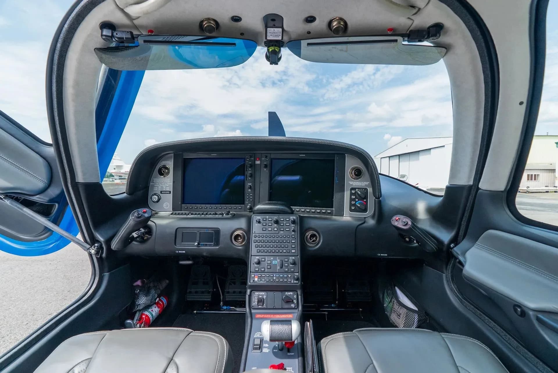 The modern glass cockpit of a Cirrus SR22 aircraft, showing dual display screens and control panel.