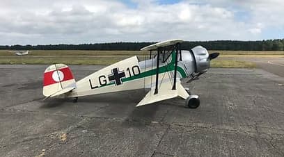 Front side view of the biplane aircraft on the tarmac.