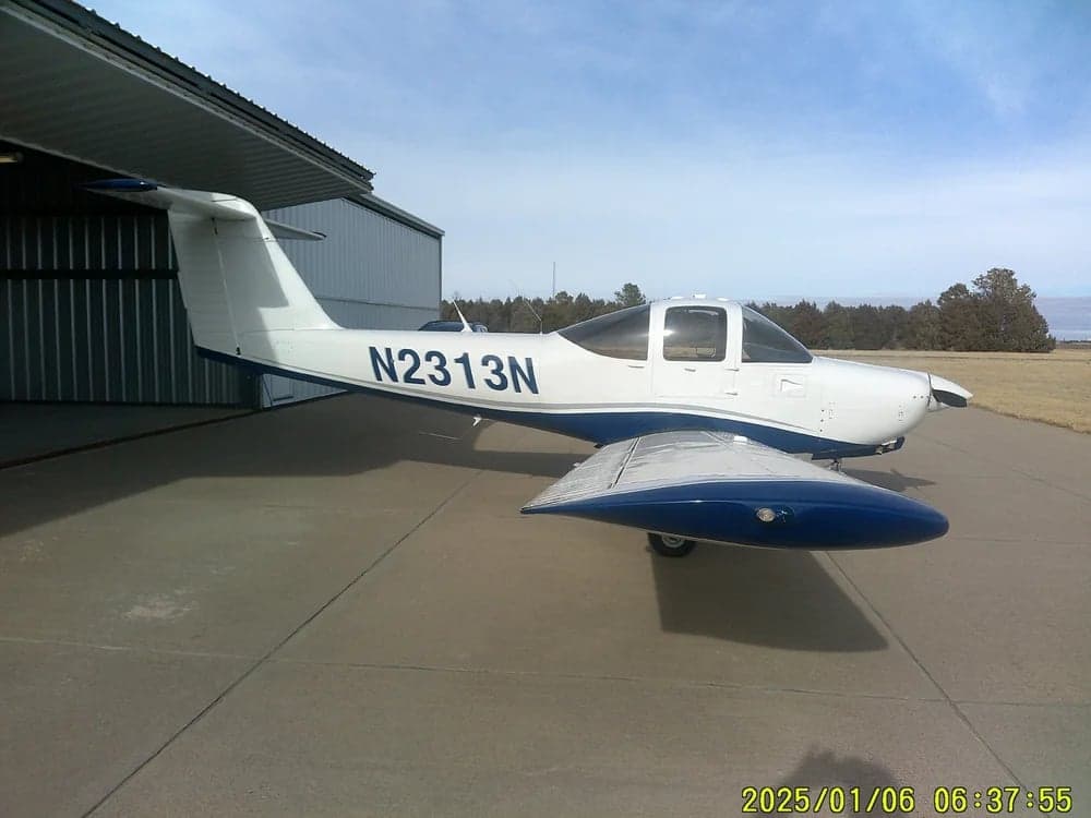 Side view of aircraft N2313N parked outside a hangar.