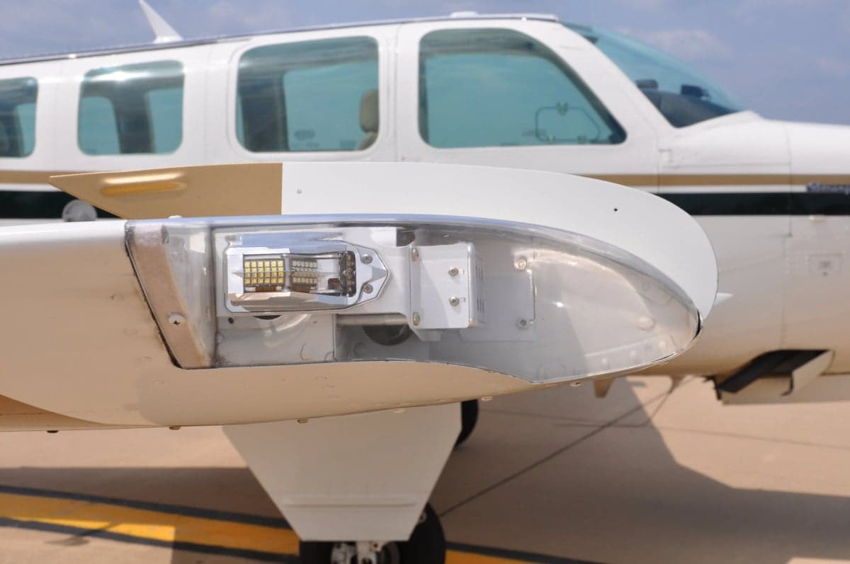 Close up of the wingtip and forward fuselage of a Beechcraft Bonanza aircraft.