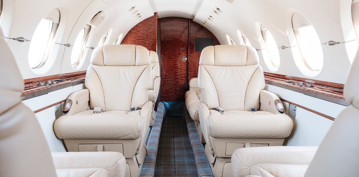 View of the aircraft's interior with cream-colored leather seats.