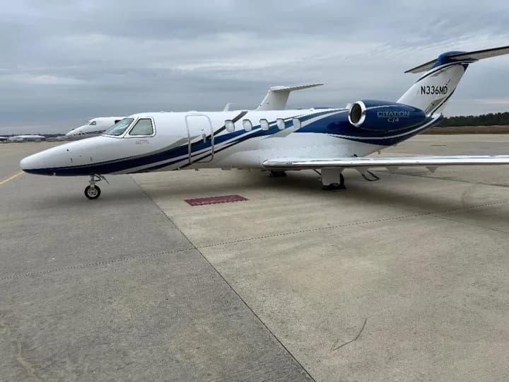 A white and blue Cessna Citation CJ4 business jet (N336MD) parked on an airport tarmac.