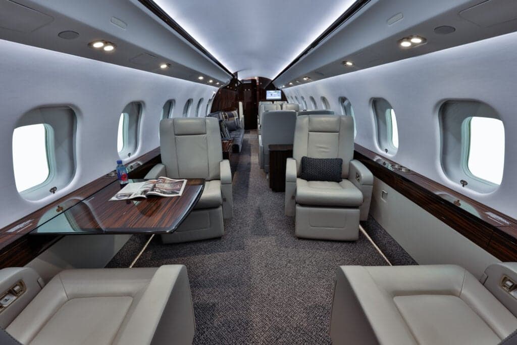 View of the aircraft interior showing the seating arrangement and a table with a magazine.