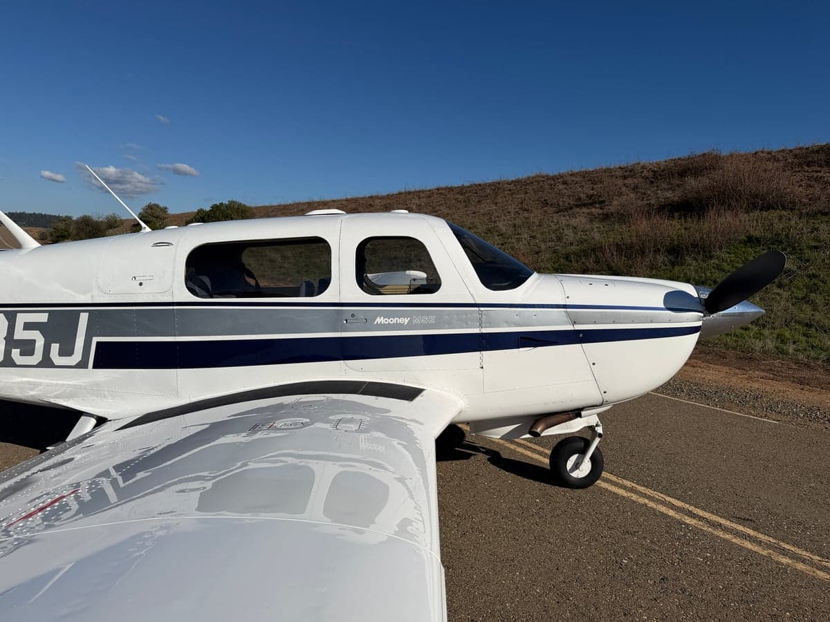 Close-up of the Mooney M20J's nose and wing, showing the registration N885J.