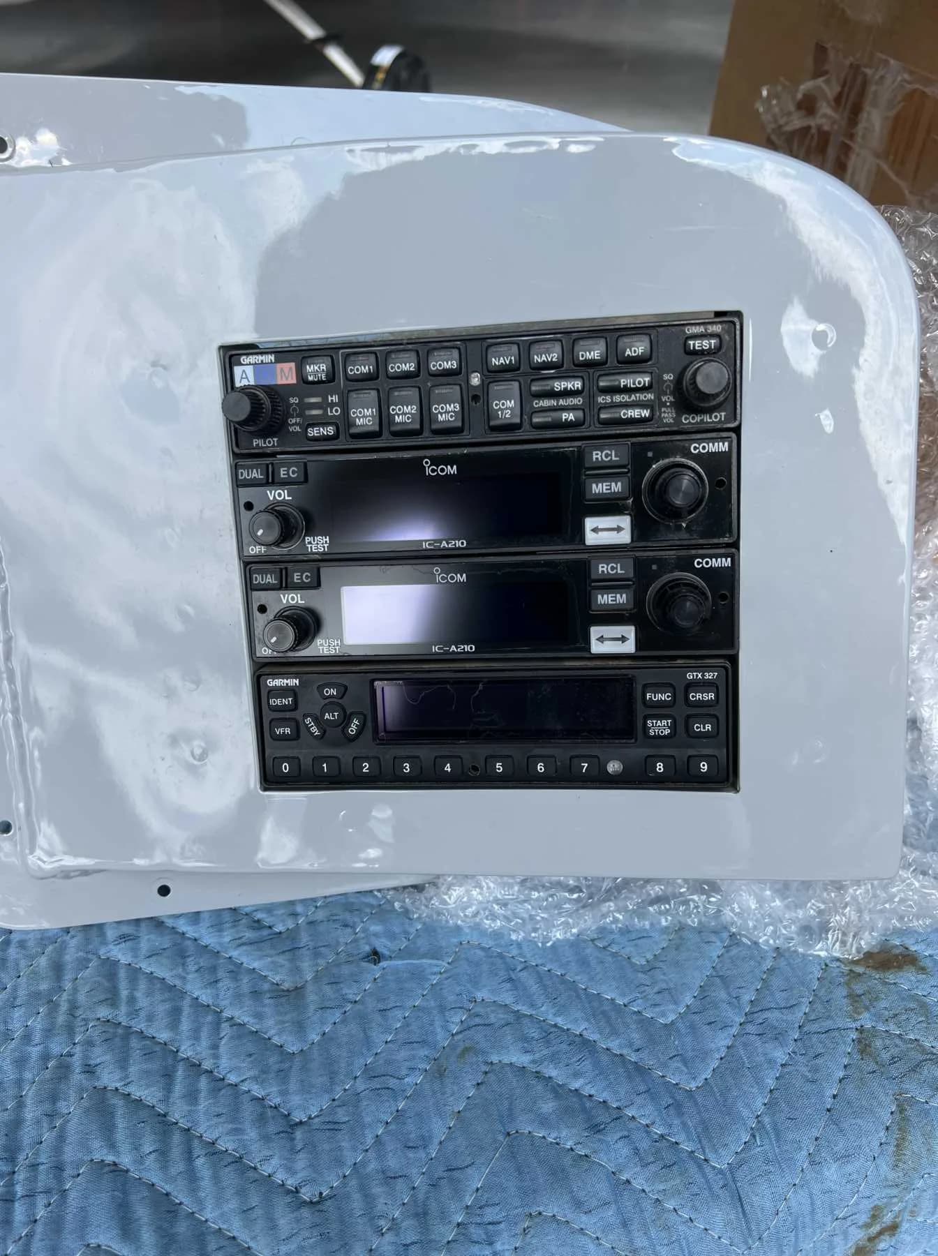 A close-up of an aircraft avionics panel with Garmin and ICOM radios.