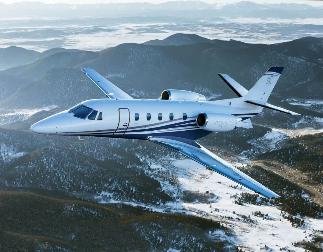 Citation XLS+ in flight over mountains.