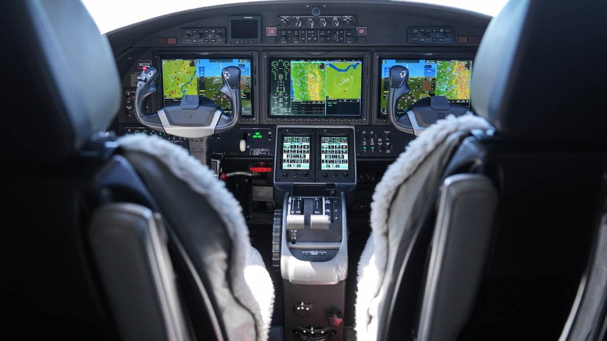 The cockpit of the aircraft features multiple display screens and controls.