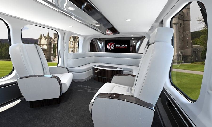 The luxurious interior of a Bell 525 helicopter with white leather seats and a lounge area.
