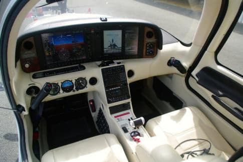 View of the aircraft's cockpit with white interior and modern avionics.