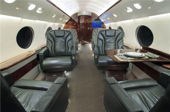 The aircraft's interior features leather seats and wood paneling.