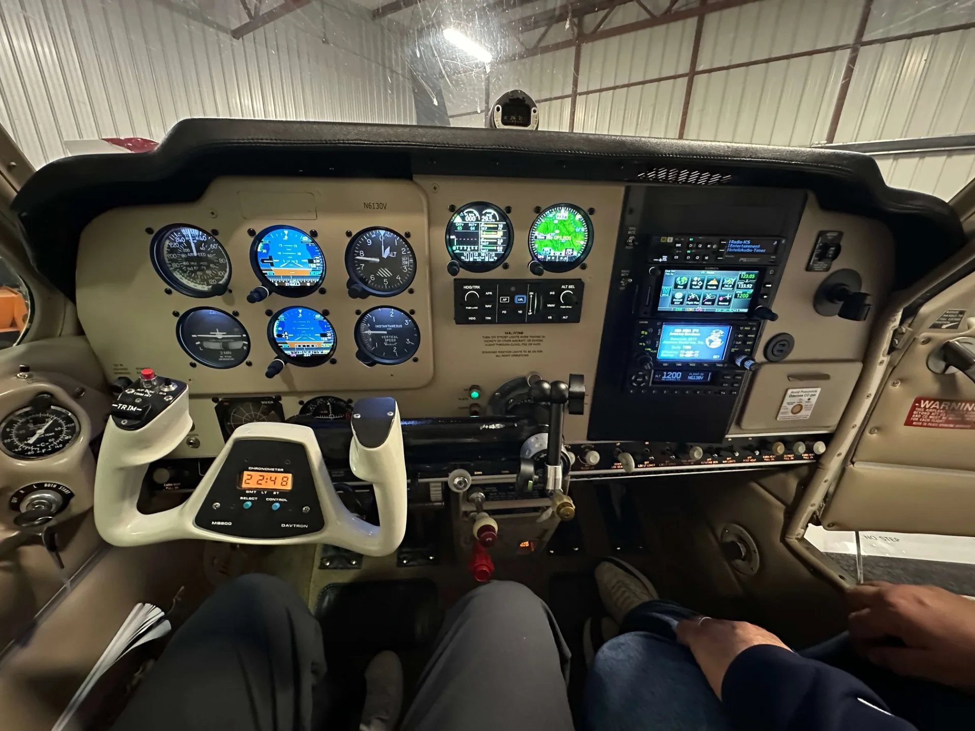 The cockpit of a Beechcraft Bonanza N6130V showing the instrument panel with analog and digital gauges, and the control yoke.