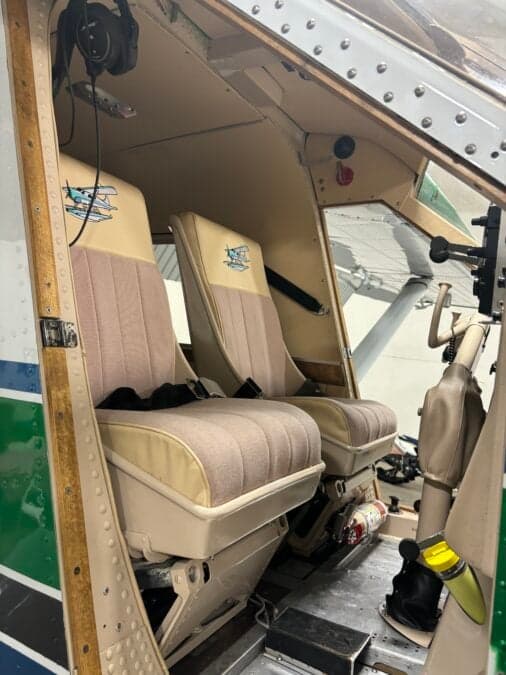 View of the front seats in the cabin, with a logo on the headrests.