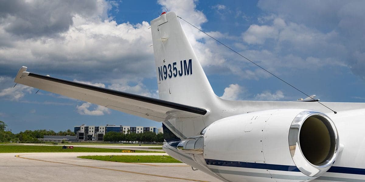 Close-up of the tail section of a Cessna Citation CJ3 aircraft, showing the registration number N935JM.