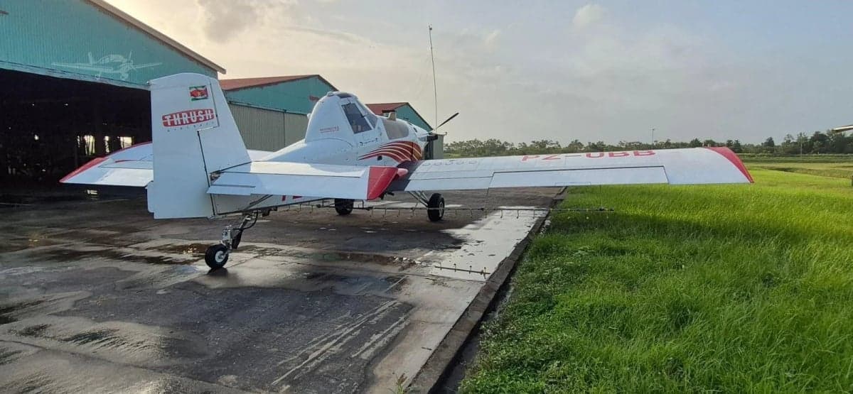 A side view of a white and red Thrush 510G crop duster aircraft with registration PZ-UBB parked on a tarmac.