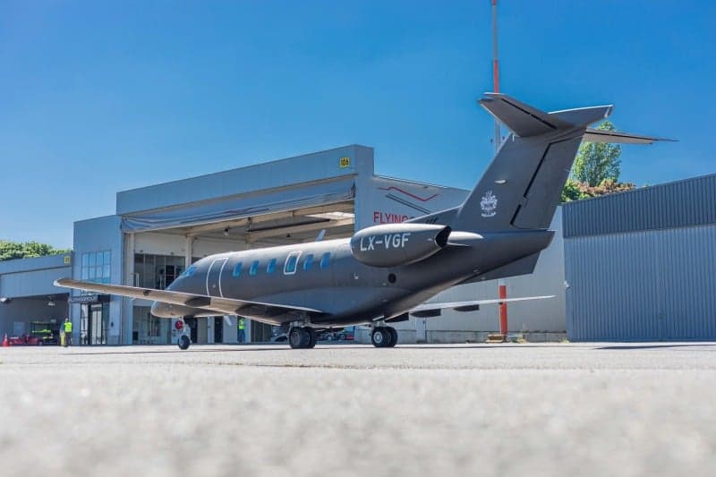 A Bombardier Challenger 350 aircraft with registration LX-VGF is parked on the tarmac at an airport.
