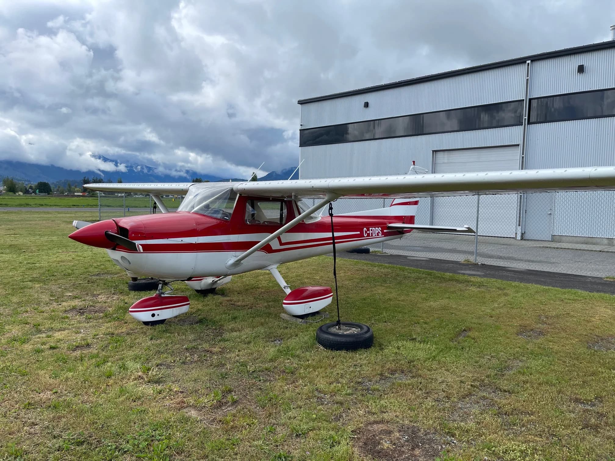 C-FDPS Cessna aircraft with red and white paint scheme, parked on the grass.