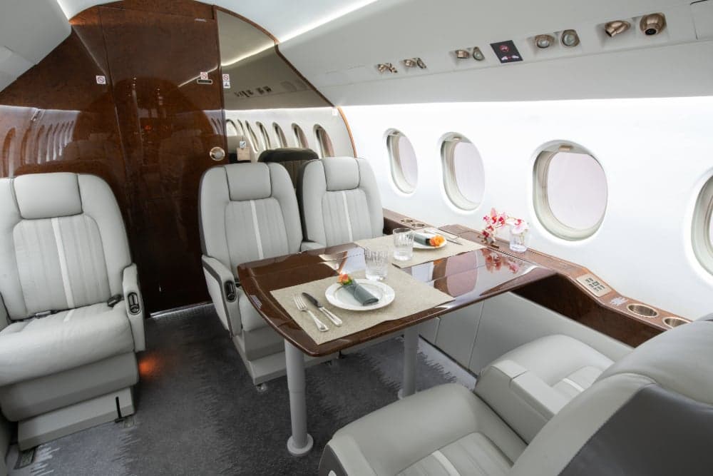 View of the aircraft interior with a dining table set for a meal.