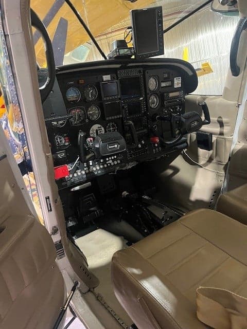 View of the Cessna 206 cockpit from the open door.
