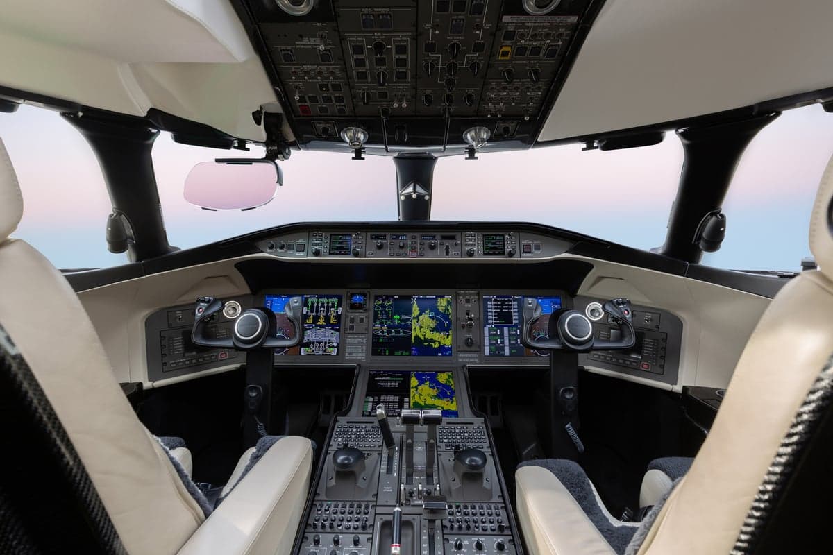 The cockpit of the aircraft with the instrument panel and seats.