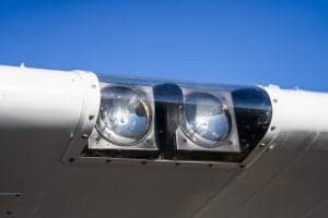 Close-up of the landing lights on the wing of a Piper Super Cub aircraft.