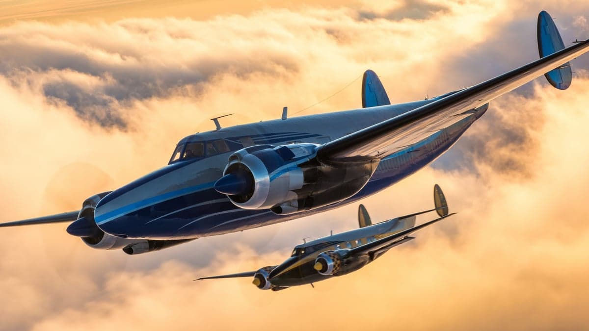 Two Beechcraft Model 18 aircraft flying in formation against a sunset sky.