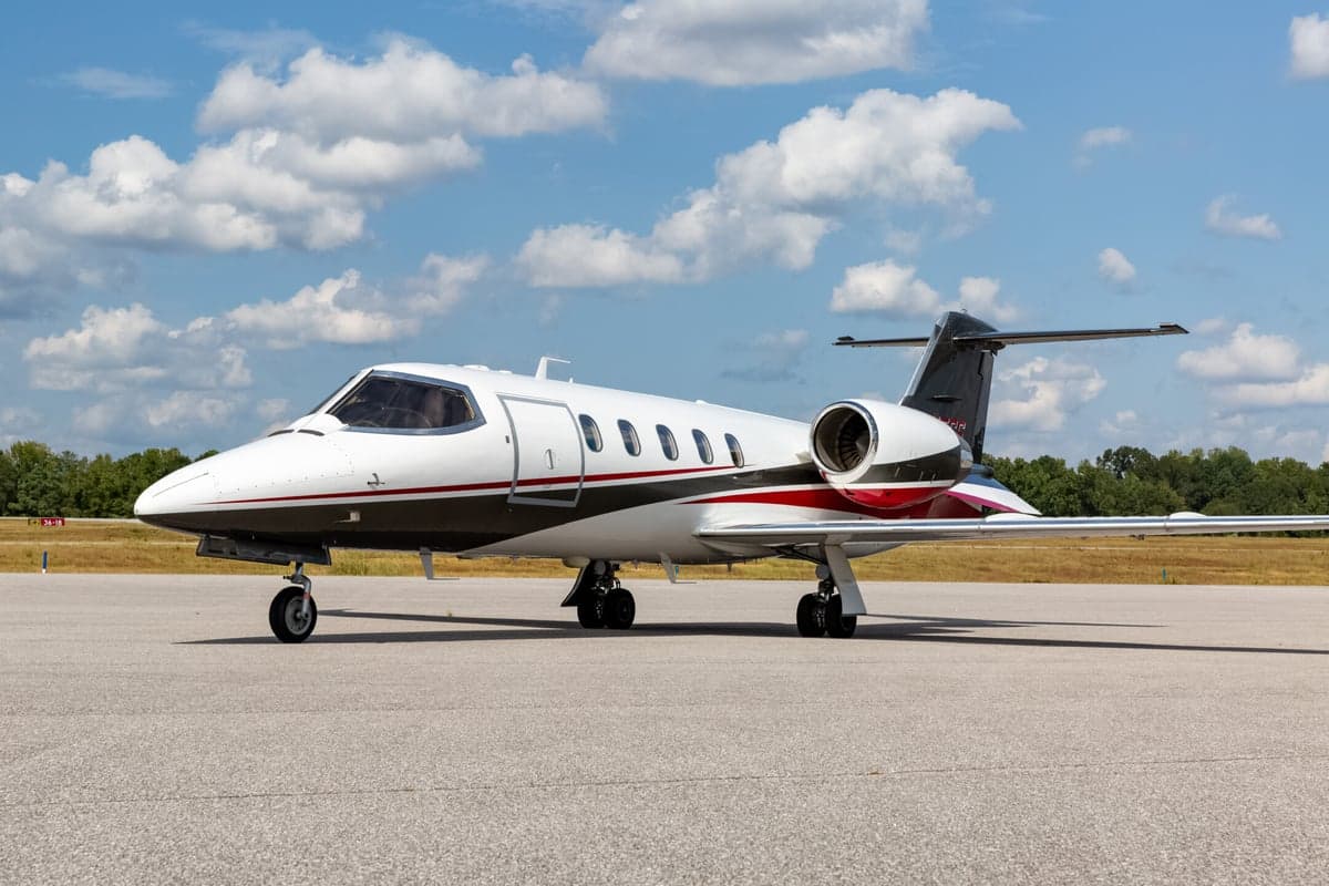 A Learjet 45XR aircraft is parked on the tarmac on a sunny day.