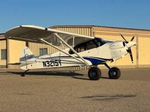 N321SY is a white and blue CubCrafters XCub parked on the tarmac.