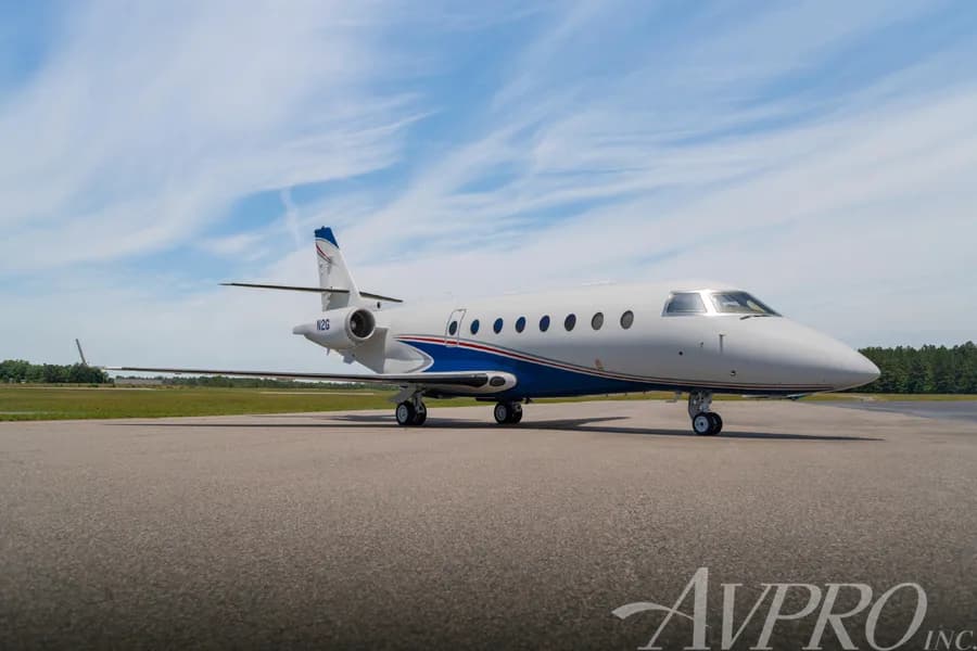 A Gulfstream G200 business jet, tail number N2G, parked on a tarmac under a blue sky.
