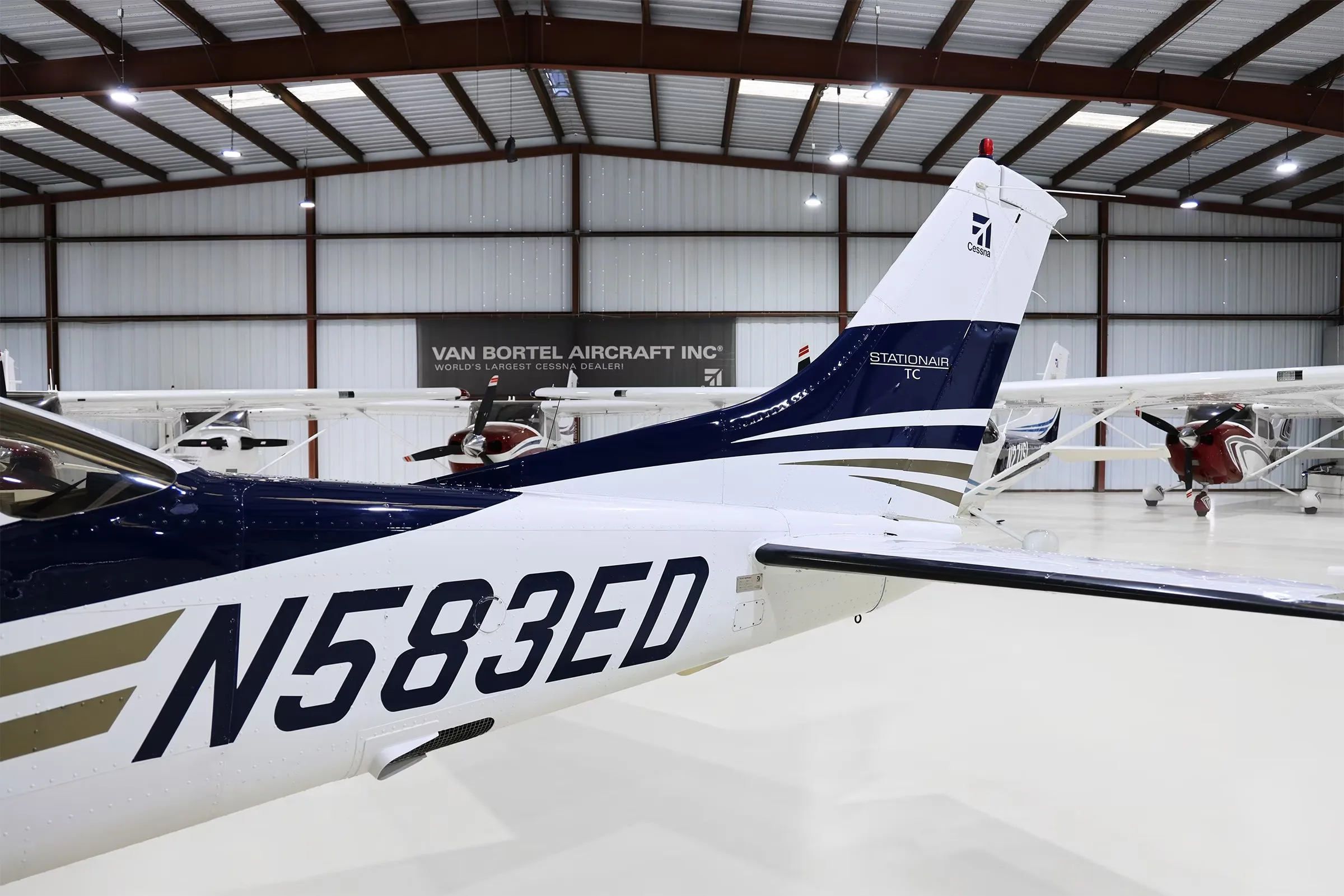 A close-up view of the tail section of the white and blue Cessna 206 Stationair TC aircraft with tail number N583ED.
