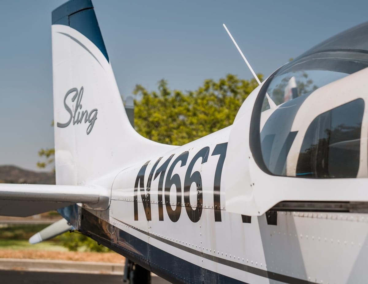 Close up of the tail and fuselage of the Sling LSA aircraft, showing the registration number N166T.