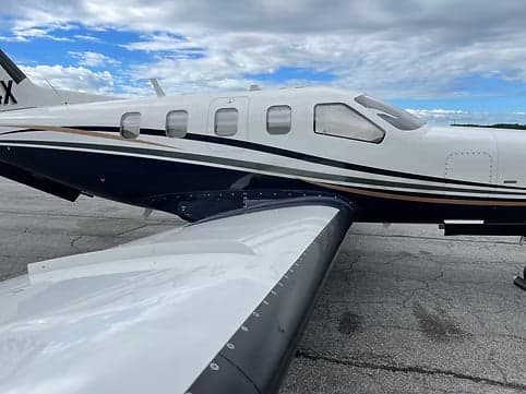 Close-up of the wing and fuselage of a turboprop aircraft.