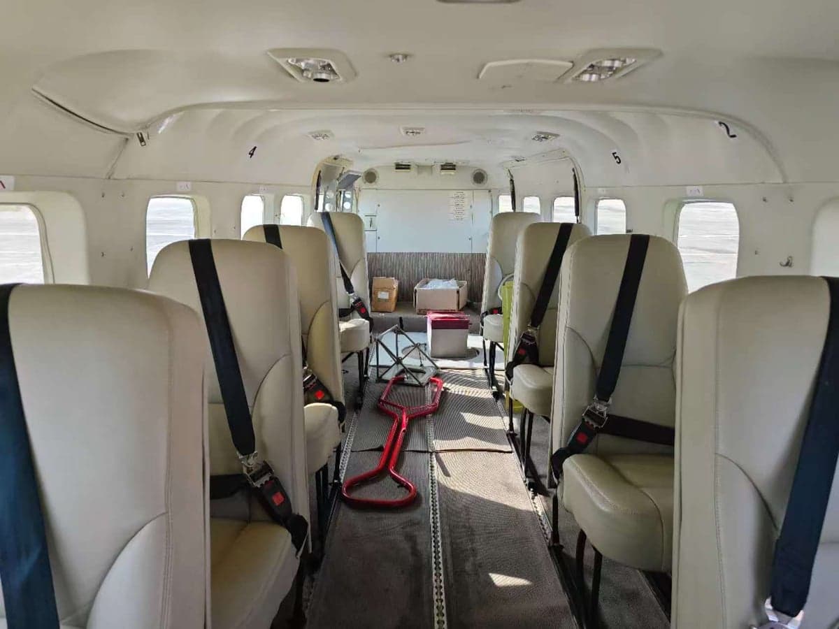 The interior of the aircraft features passenger seats with seatbelts.