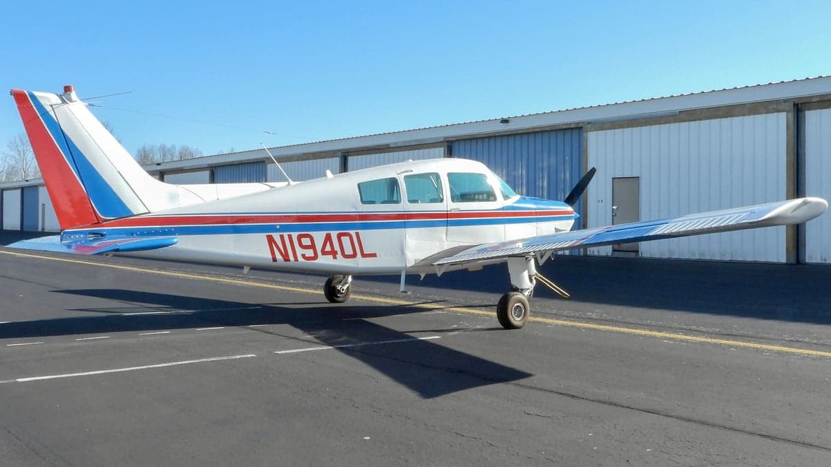 Side view of a Piper PA-28-140 Cherokee with tail number N1940L parked on the tarmac.