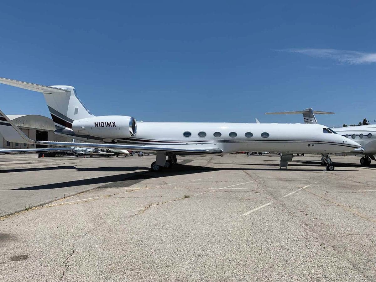 Side view of a white Gulfstream jet with registration N101MX on the ramp.