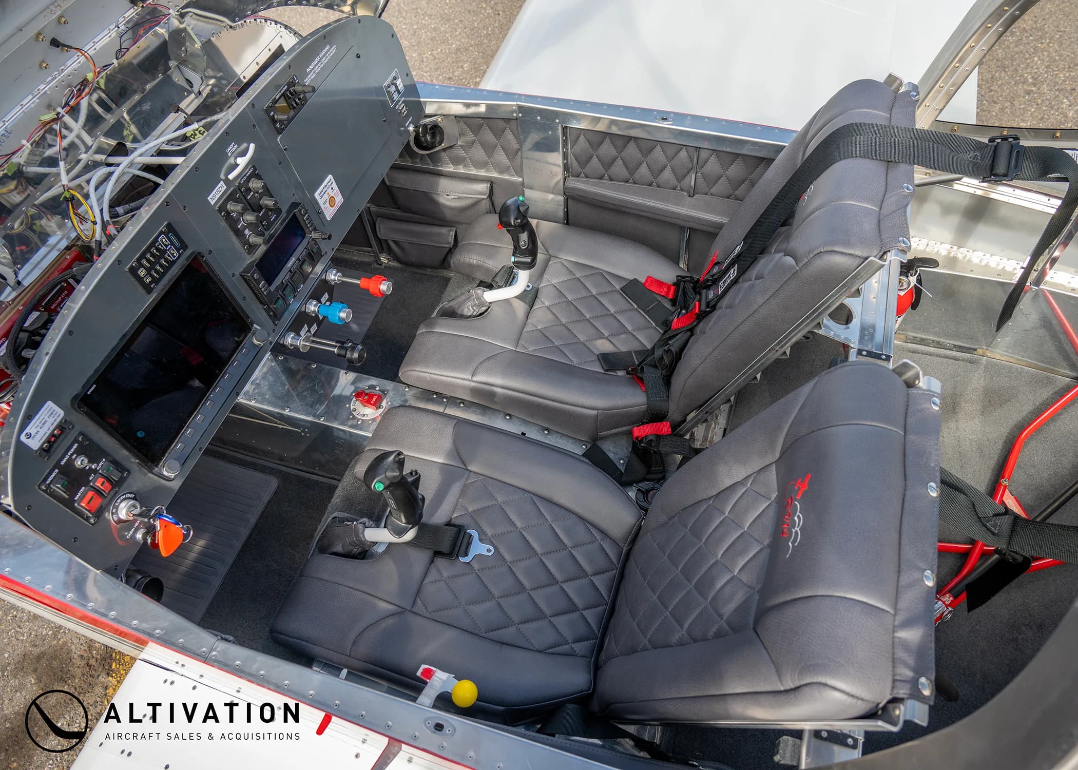 An overhead view of the experimental aircraft's interior, showing the cockpit, dual stick controls, and two quilted seats.