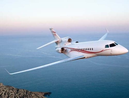 A Dassault Falcon jet flying over the ocean.