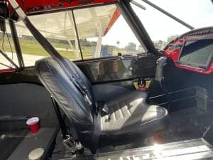 The interior of the aircraft features a black leather seat and a red cup.