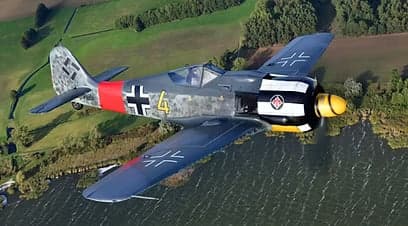 A Focke-Wulf Fw 190 and a Supermarine Spitfire aircraft in flight over a rural landscape.
