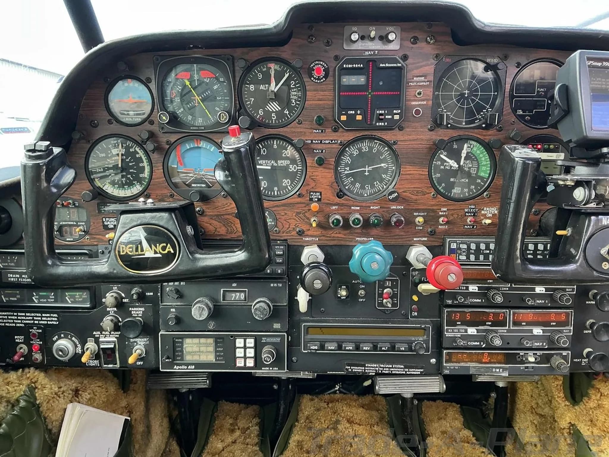 A detailed view of the Bellanca Viking's cockpit instrument panel with a woodgrain finish and various gauges.