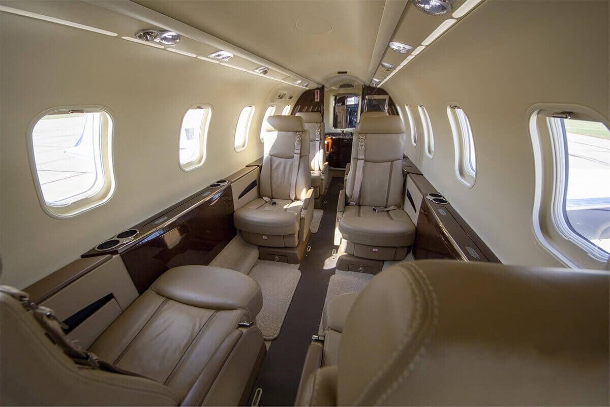 The interior of the aircraft features leather seats and wood trim.